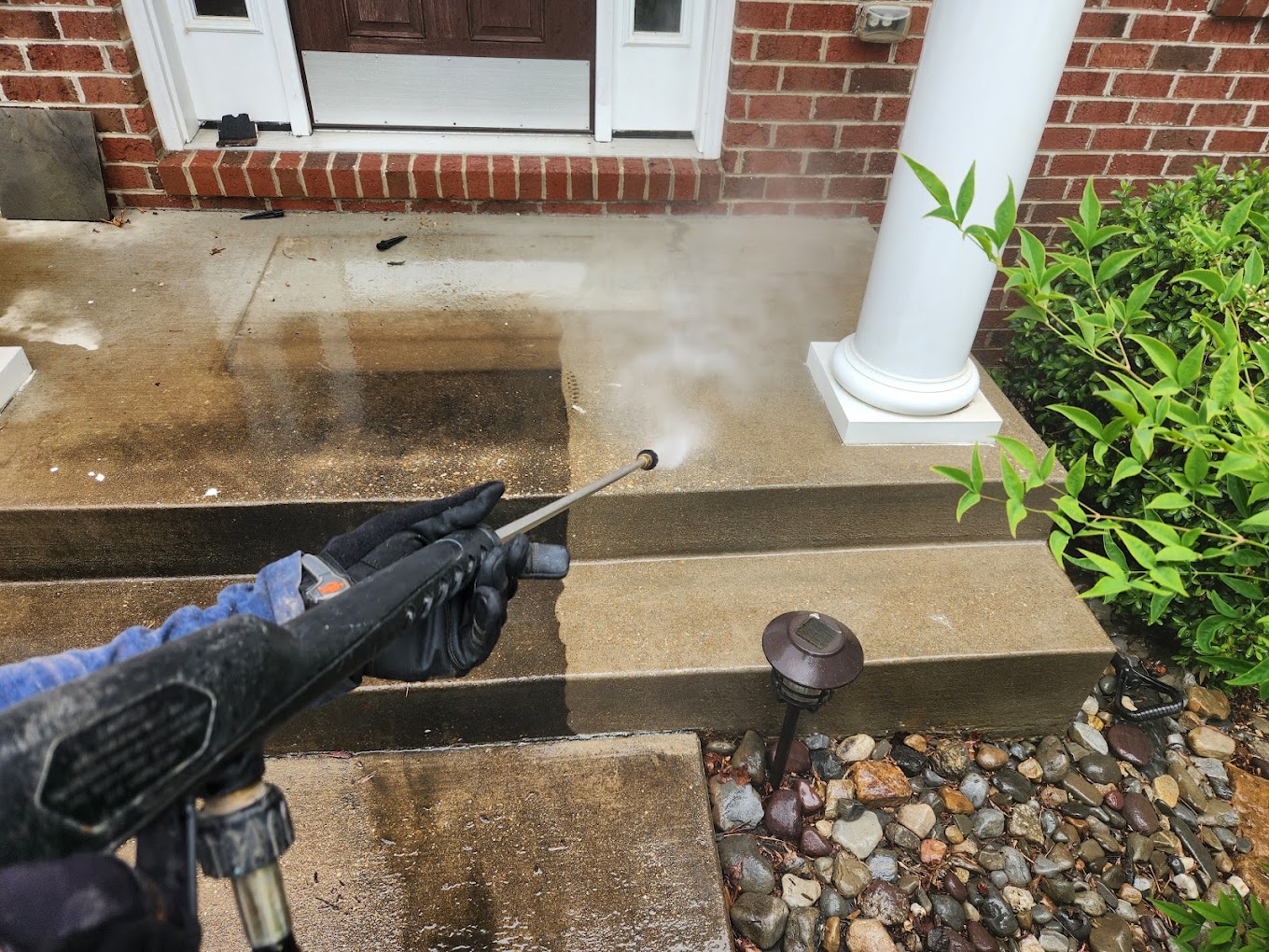 Pressure washer cutting through built-up grime on concrete steps